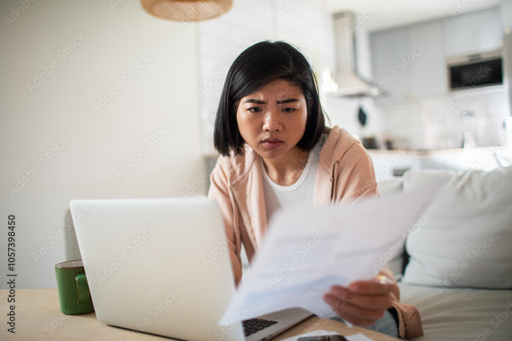 Asian woman working on laptop from home couch Asian woman working on laptop from home couch