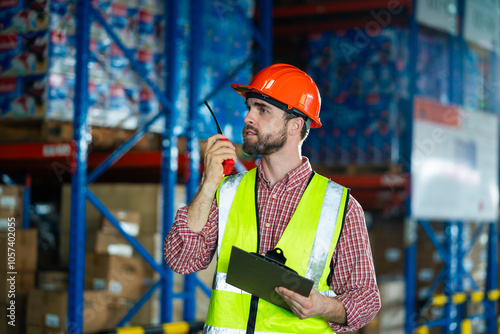 Billede på lærred A man in a yellow vest and orange hat is standing in a warehouse