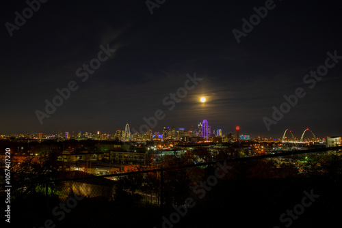 Beautiful View Of The Margaret Hunt Hill And The Margaret McDermott Bridges And The Bright Neon Lights Of The Downtown Dallas Skyline Under Full Moon Lighting