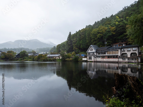 A reflection of Kinrin Lake, framed by trees and mountains in Yufu, Oita Prefecture, Japan. photo