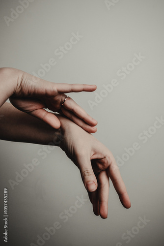 Two human hands making delicate and expressive gestures against a plain background. Abstract hands gestures. Communication, expression, feelings, art concepts. 