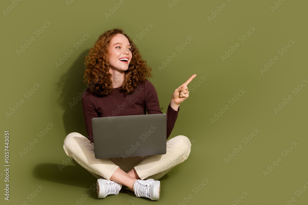 Full length photo of adorable lovely girl wear brown shirt studying modern gadget showing empty space isolated khaki color background Full length photo of adorable lovely girl wear brown shirt studying modern gadget showing empty space isolated khaki color background