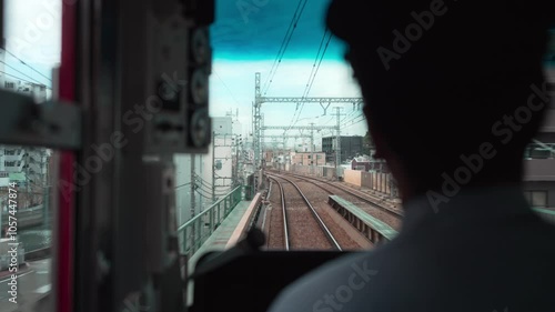 電車を運転する運転士と正面の景色