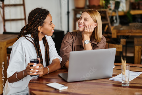 Two women are enjoying each other's company at a cae, filled with laughter and love as they share a drink.