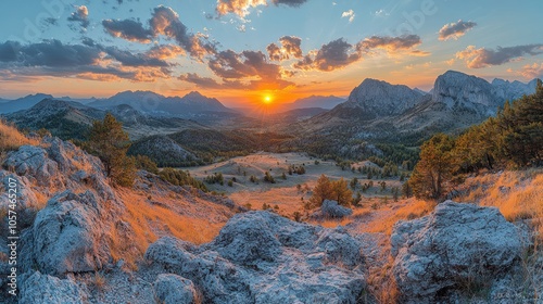 A stunning sunset over a valley with rugged mountains in the background.