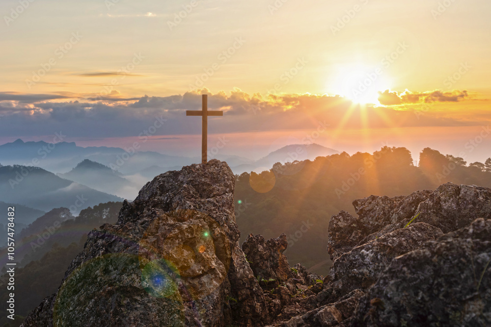 Silhouettes of crucifix symbol on top mountain with bright sunbeam on the colorful sky background Silhouettes of crucifix symbol on top mountain with bright sunbeam on the colorful sky background