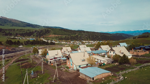 Aerial view of a quaint village in the mountains of Kyrgyzstan surrounded by green landscape