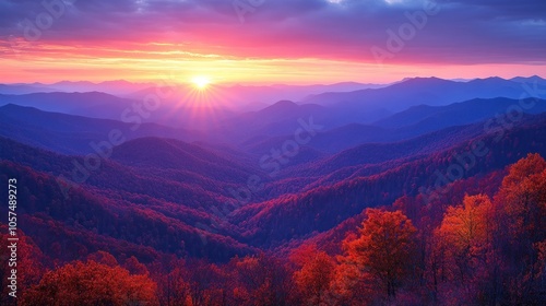 Majestic sunrise over layered mountains with vibrant autumn foliage.