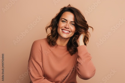 Portrait of a satisfied woman in her 30s wearing a cozy sweater on blank studio backdrop