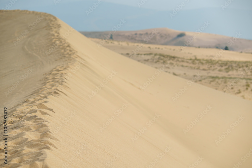 Golden desert dunes illuminated by sunbeams under a dramatic sky