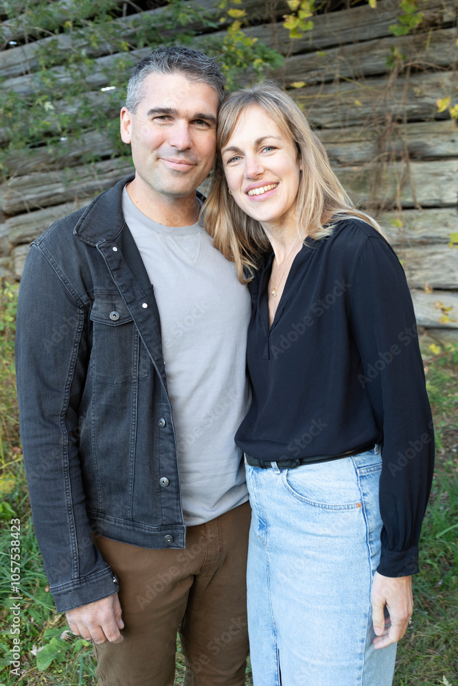 Portrait of a married couple smiling and standing in front of a wooden building in Beckwith Township at Carleton Place in the Ottawa Valley; Ontario, Canada Portrait of a married couple smiling and standing in front of a wooden building in Beckwith Township at Carleton Place in the Ottawa Valley; Ontario, Canada