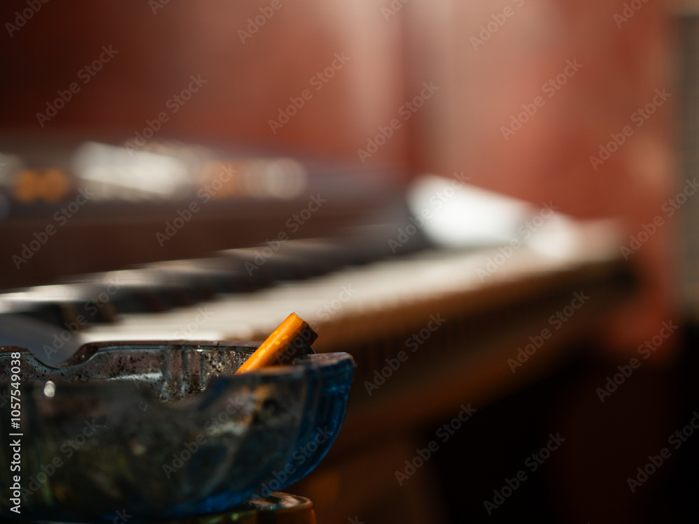 Cigarette in bar near with piano organ musical instrument Cigarette in bar near with piano organ musical instrument