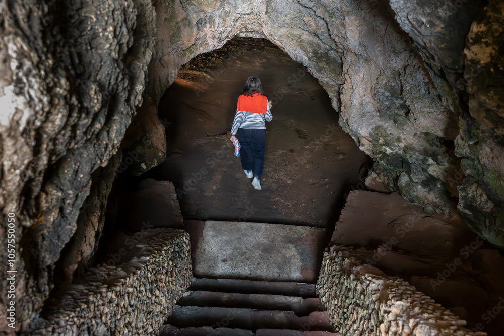 Woman enters the Cave of Lapa de Santa Margarida; Sao Lourenco, Setubal, Portugal Woman enters the Cave of Lapa de Santa Margarida; Sao Lourenco, Setubal, Portugal