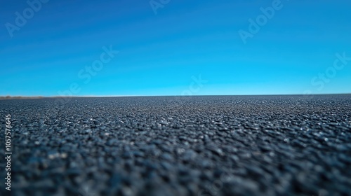 Clear blue sky over a smooth asphalt surface photo