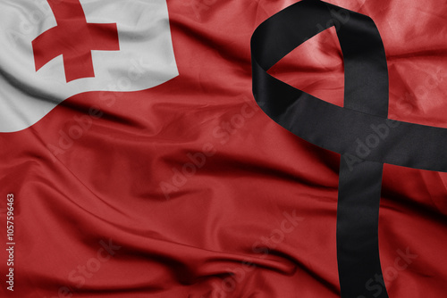 waving national flag of Tonga with black mourning ribbon . tragedy concept