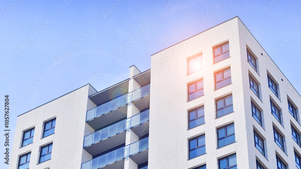 Modern high-rise apartment building in white, stand tall against a blue sky, exemplifying innovative urban architecture with sleek, angular designs. Modern high-rise apartment building in white, stand tall against a blue sky, exemplifying innovative urban architecture with sleek, angular designs.