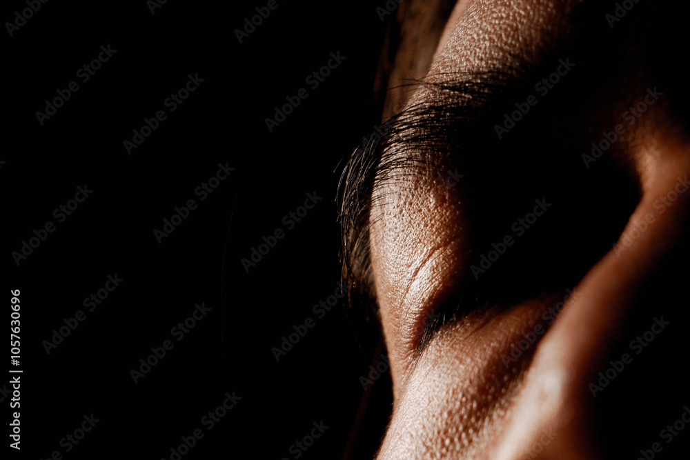 Close up of a man's face with his eyes closed in low light Close up of a man's face with his eyes closed in low light