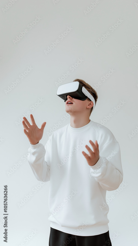 A young man wearing a modern VR headset, looking upwards with an expression of amazement, isolated on a white background, hands slightly raised as if interacting with a virtual world