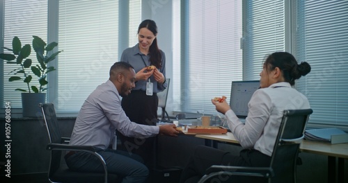 Photos Multiethnic team of technical customer support specialists talk and eat pizza delivery for lunch