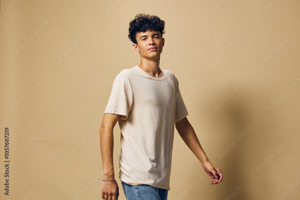 Casual portrait of a young man in a beige t shirt, posing confidently on a neutral background, showcasing modern fashion and personal style, ideal for lifestyle and fashion themes Casual portrait of a young man in a beige t shirt, posing confidently on a neutral background, showcasing modern fashion and personal style, ideal for lifestyle and fashion themes