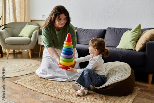 A mother and daughter share laughter while stacking colorful rings on a cozy afternoon. photo