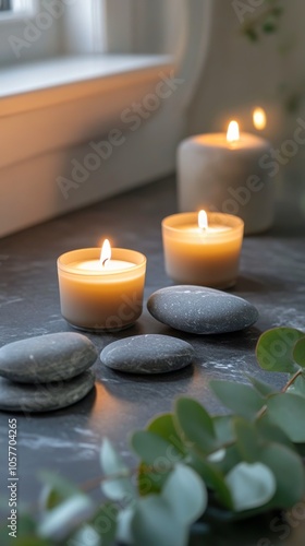 Tranquil arrangement of stones and candles with eucalyptus leaves in a calmin...
