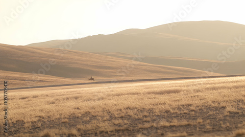 A lone figure rides through a dry, grassy plain in the fading light of sunset, with a mountain range in the background.