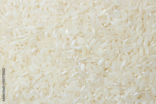 Dry Uncooked White Rice Background - Top View, Flat Lay. Scattered Raw Long Grain Rice. Asian Cuisine and Culture. Healthy Eating Ingredients. Diet Food