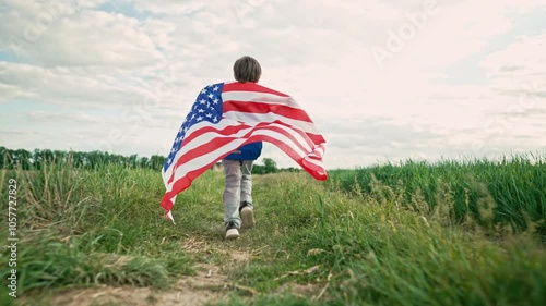 Cute little boy - American patriot kid running with national flag on open area countryside road.USA, 4th of July - Independence day, celebration. US banner, memorial Veterans, election