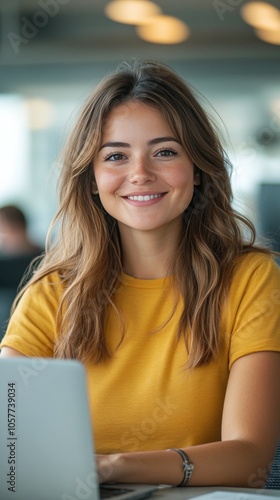 Young woman working on laptop in a bright, plant filled workspace during dayl...