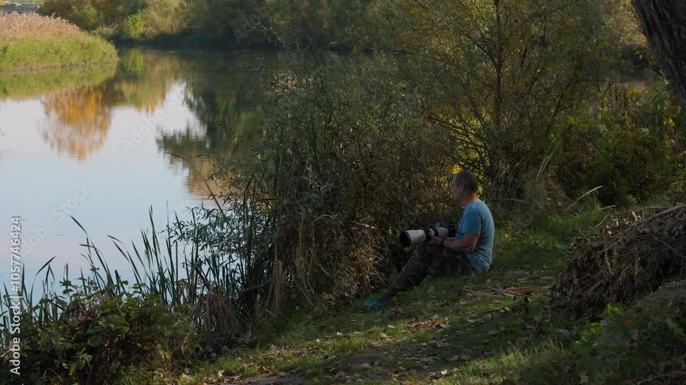 4k, wildlife photographer stands on the bank of a river.
4k, wildlife photographer stands on the bank of a river.