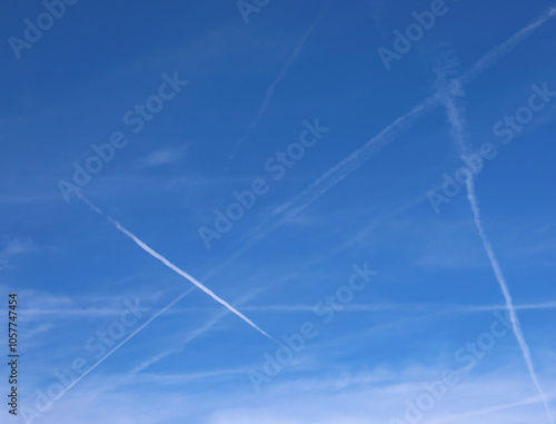 white chemtrails against a clear blue sky fuel speculation of a global conspiracy photo