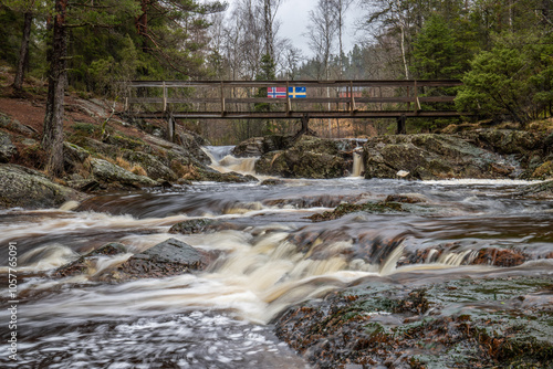 Landscape shot of a large waterfall in the forest and nature. Autumn landscape The Elgafossen Vattenfall river provides a natural border between Sweden and Norway at Vassbotten, Scandinavia photo