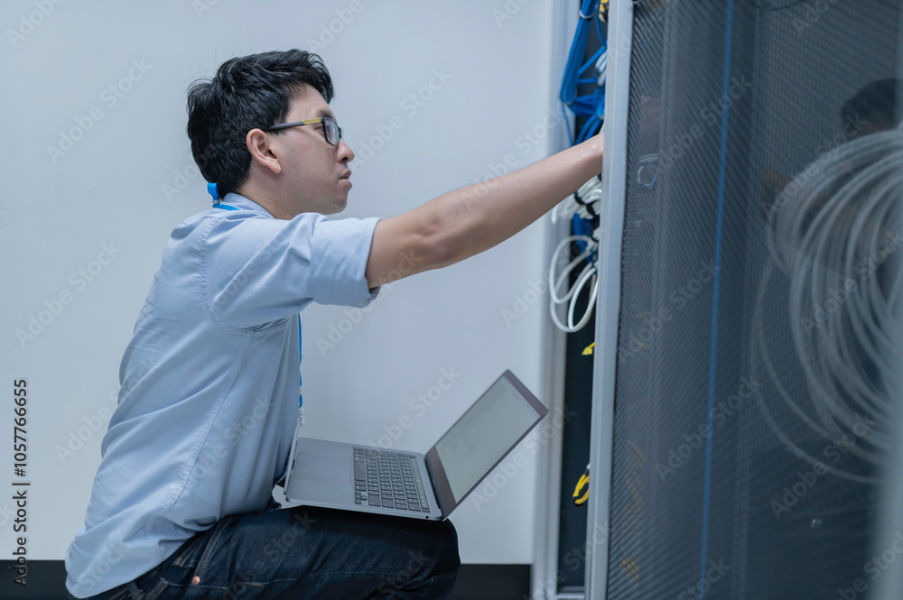 Computer engineer is setting up network in server room,Systems Maintenance Technician,Male engineer working in server room at modern data center Computer engineer is setting up network in server room,Systems Maintenance Technician,Male engineer working in server room at modern data center
