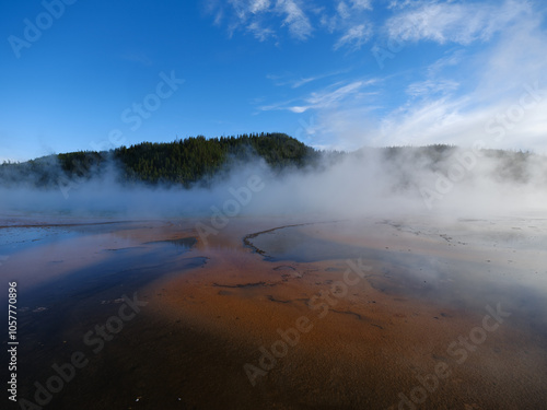 Textures and colors in the Grand Prismatic Springs of Yellowstone National Park with steam rising from the hot boiling waters That flow into the Riverhole river nearby 