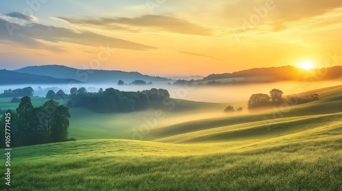 Sunrise breaking through morning fog over rolling hills, foggy weather, peaceful dawn.