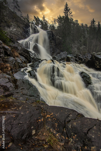 Landscape shot of a large waterfall in the forest and nature. Autumn landscape The Elgafossen Vattenfall river provides a natural border between Sweden and Norway at Vassbotten, Scandinavia photo