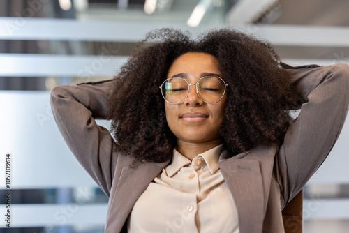 Fotografie African American young business woman in a suit sitting at a chair in the office and resting