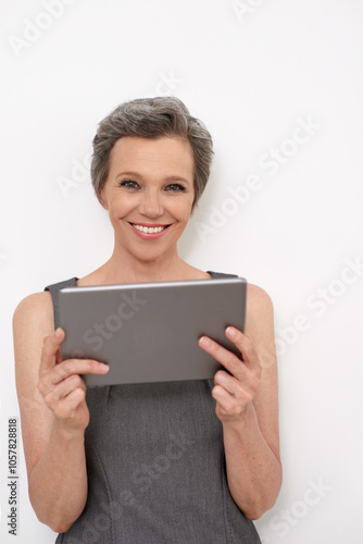 Tablet, smile and portrait of businesswoman in studio for KPI reports, research or email communication. Happy, digital technology and mature female financial executive from London by white background