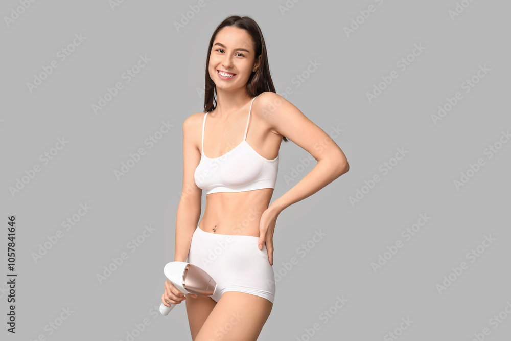 Happy young woman with modern photoepilator on grey background Happy young woman with modern photoepilator on grey background