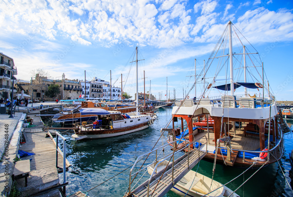 view of kyrenia town and boats in the harbor at the cyprus under cloudy blue sky view of kyrenia town and boats in the harbor at the cyprus under cloudy blue sky