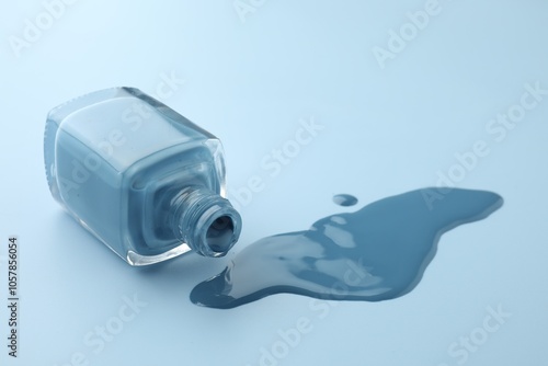 Bottle of nail polish on light blue background, closeup photo