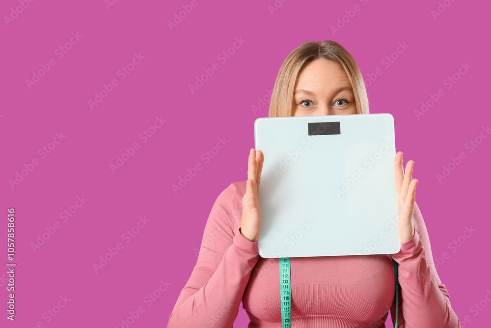 Pretty young woman in sportswear with scales on pink background. Weight loss concept Pretty young woman in sportswear with scales on pink background. Weight loss concept