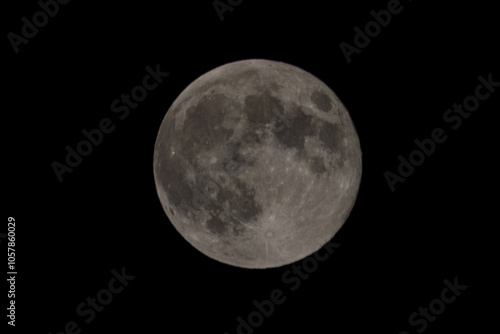 The full moon surface close up that lights up in the night.