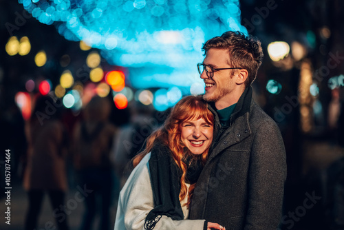 Loving christmas couple hugging and laughing on christmas eve on street