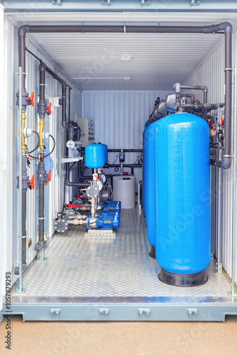 Obraz na płótnie Industrial water filtration system inside container with blue tanks, pipes, machinery, valves, clean water solution w salonie