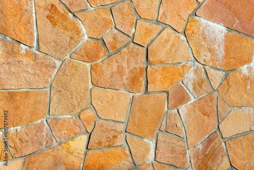 Obraz na płótnie Natural stone wall with textured surface displaying rustic patterns, interlocking shapes, and warm earthy tones, architectural design concept w salonie