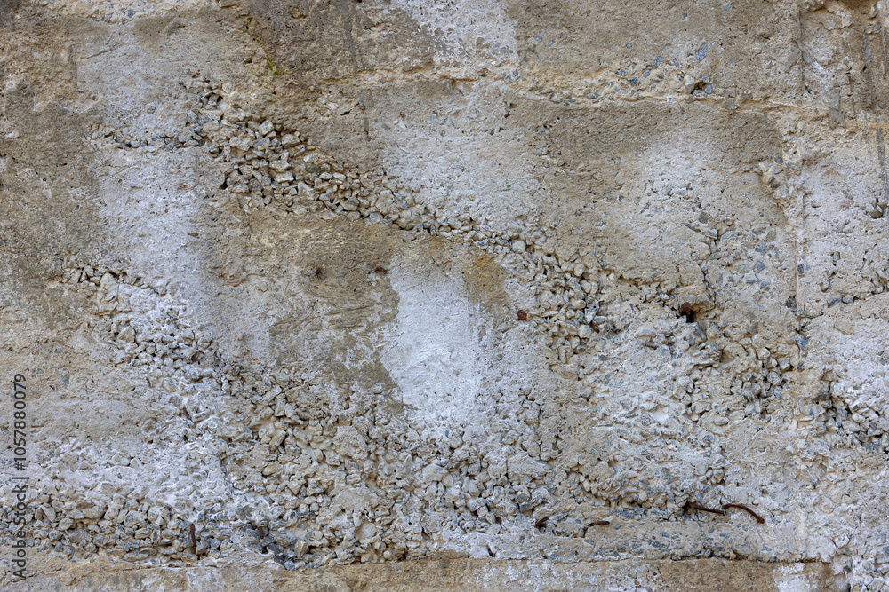 Textured Concrete Wall with Cracks and Pebbles, Weathered Stone Surface, Rugged Architecture, Concrete Texture Concept