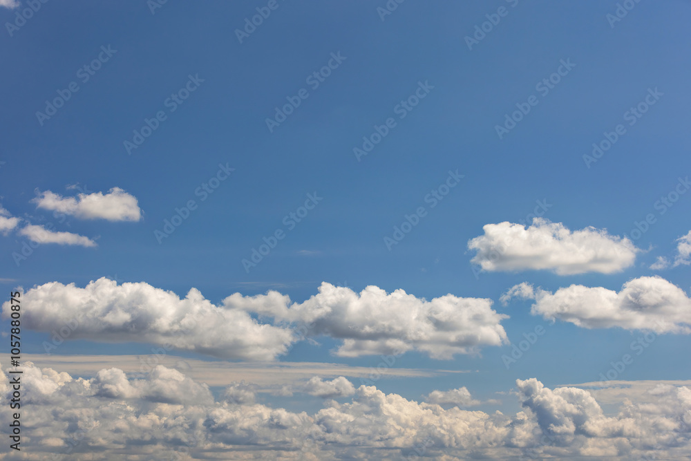Blue sky with fluffy white clouds, serene background, peaceful skyward view, tranquility and freedom above, calm atmosphere concept