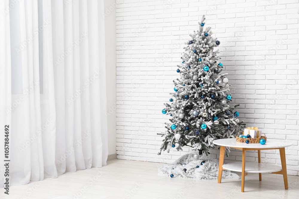 Coffee table with gift, balls and decorated Christmas tree near white brick wall in room Coffee table with gift, balls and decorated Christmas tree near white brick wall in room